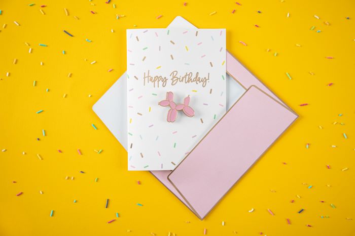 Hvidt fødselsdagskort med ballonhund og konfetti motiver med kuvert - 14,8x10,5 cm